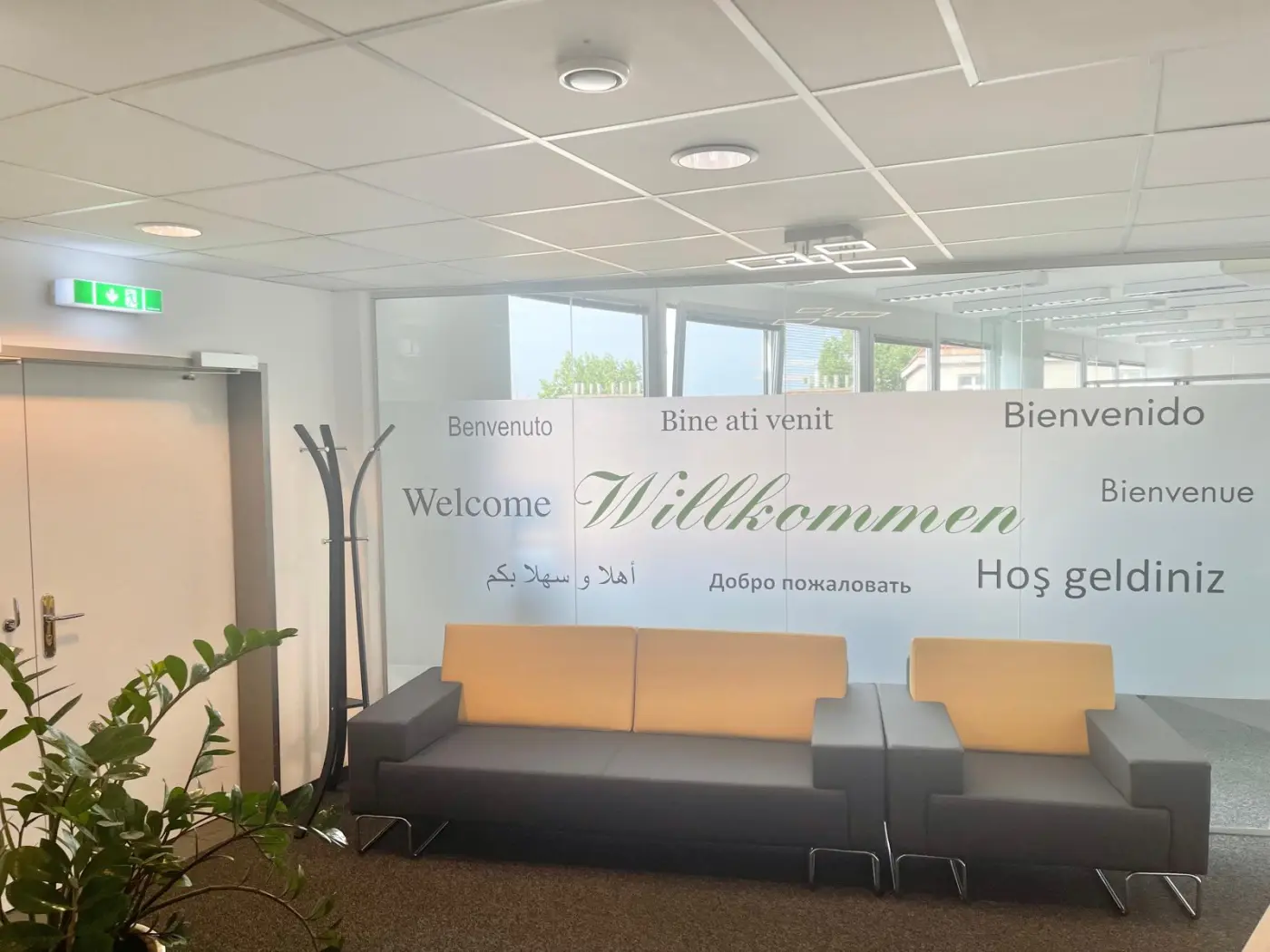 Einladender Empfangsbereich von Compas mit mehrsprachiger Willkommens-Wand